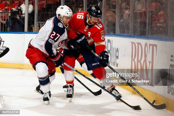 Aleksander Barkov of the Florida Panthers digs the puck out from the boards against Ryan Murray of the Columbus Blue Jackets at the BB&T Center on...