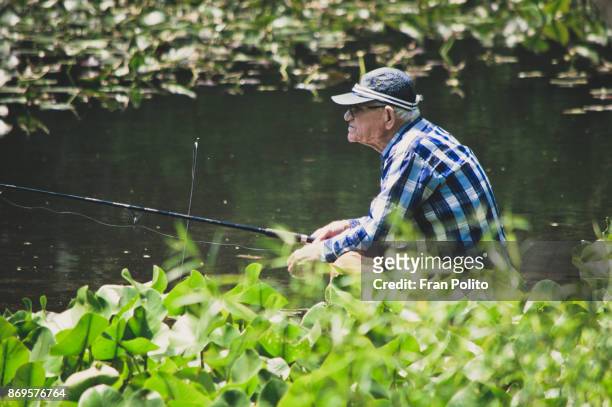 a retired active senior man fishing. - baldwin brothers stock pictures, royalty-free photos & images