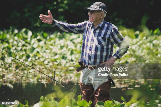 a healthy retired older man out fishing. - baldwin brothers stock pictures, royalty-free photos & images