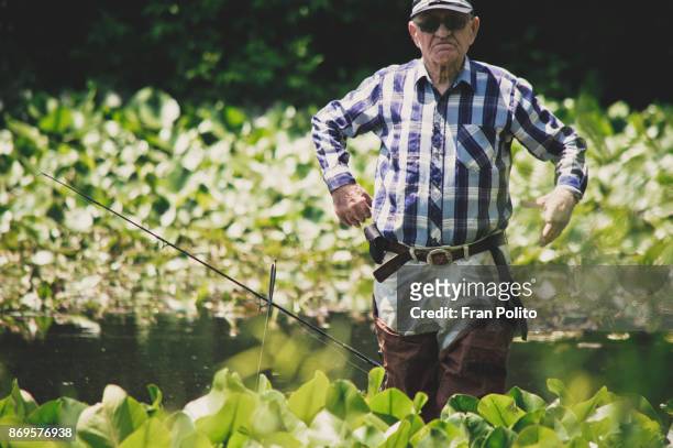 a healthy active senior man out fishing. - baldwin brothers stock pictures, royalty-free photos & images