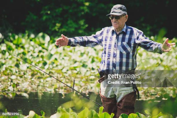 an active senior man fishing. - baldwin brothers stock pictures, royalty-free photos & images