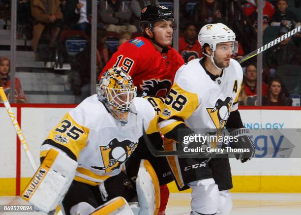 Matthew Tkachuk of the Calgary Flames battles against Kris Letang and Tristan Jarry of the Pittsburg Penguins at Scotiabank Saddledome on November 2,...