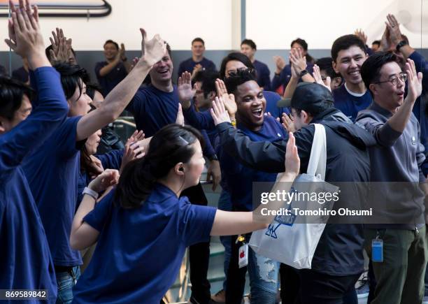 Employees give high-fives to customers as they enter the Apple Omotesando store to purchase the iPhone X on November 3, 2017 in Tokyo, Japan. Apple...