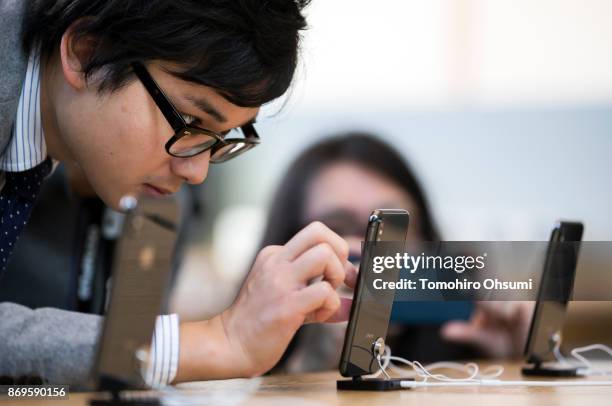 Customer tries an iPhone X at the Apple Omotesando store on November 3, 2017 in Tokyo, Japan. Apple launched the latest iPhone featuring face...