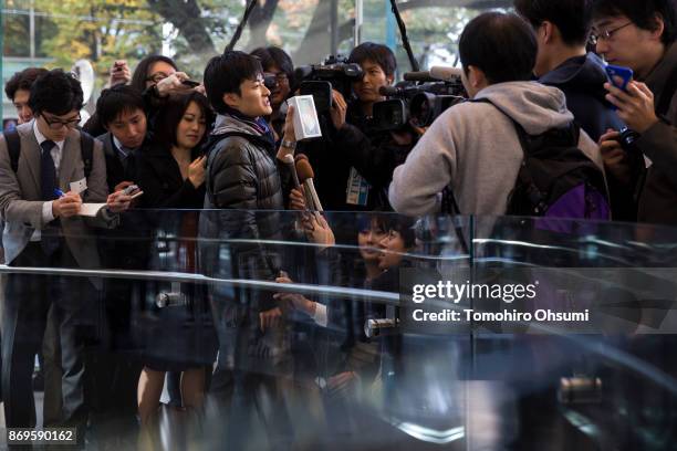 The first customer to the Apple Omotesando store holds a box containing his iPhone X as he speaks to the media on November 3, 2017 in Tokyo, Japan....