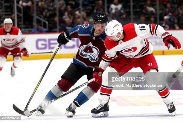 Carl Soderberg of the Colorado Avalanche fights for control of the puck against Marcus Kruger of the Carolina Hurricanes at the Pepsi Center on...