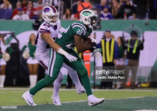 Matt Forte of the New York Jets scores a touchdown as Micah Hyde of the Buffalo Bills defends during the third quarter of the game at MetLife Stadium...