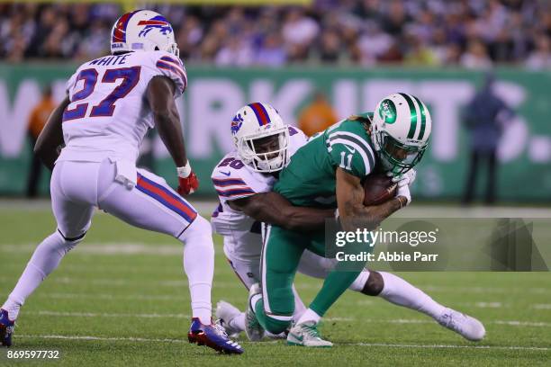 Wide receiver Robby Anderson of the New York Jets is tackled by cornerback Shareece Wright of the Buffalo Bills as cornerback Tre'Davious White looks...