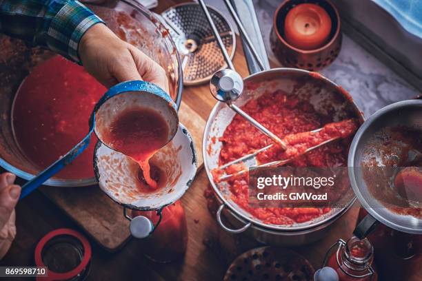 preparing homemade tomato sauce and preserving in bottles - preserving stock pictures, royalty-free photos & images