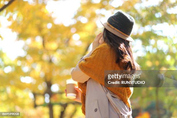 woman talking on the cellphone in autumn park - ショール ストックフォトと画像