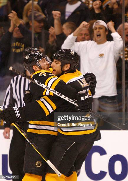 Milan Lucic of the Boston Bruinshas scores a goal and celebrates with teammate Michael Ryder against the Carolina Hurricanes the during Game Five of...