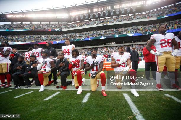 Members of the San Francisco 49ers kneel during the anthem prior to the game against the Philadelphia Eagles at Lincoln Financial Field on October...