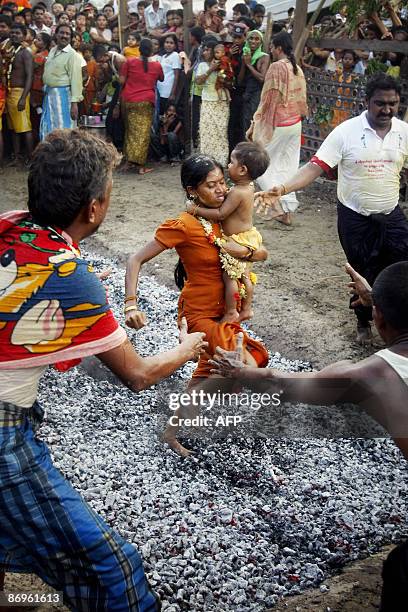 Photo taken May 8, 2009 shows a Hindu woman as she runs over hot coals during a fire festival in the Yankin township of Kanbet in Yangon, Myanmar....