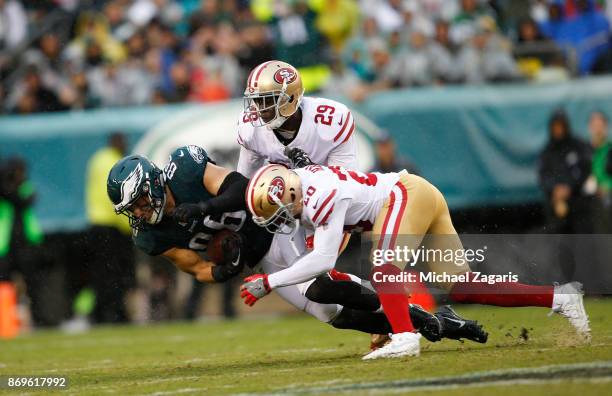 Jaquiski Tartt and Leon Hall of the San Francisco 49ers tackle Zach Ertz of the Philadelphia Eagles during the game at Lincoln Financial Field on...