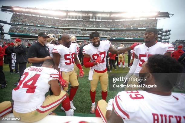 Elvis Dumervil, Dekoda Watson and Eli Harold of the San Francisco 49ers talk on the sideline during the game against the Philadelphia Eagles at...