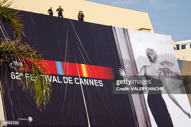 People set up the official poster of the Cannes' film festival 62nd edition on the Festivals' palace facade on May 11, 2009 in Cannes, south eastern...