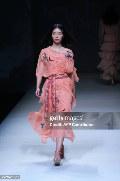 This photo taken on November 2, 2017 shows a model parading a creation from the "VIVIENNE TAM" collection of the US during China Fashion Week in...