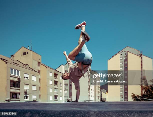 breakdancer dancing on a roof in a city - break dancer stock pictures, royalty-free photos & images