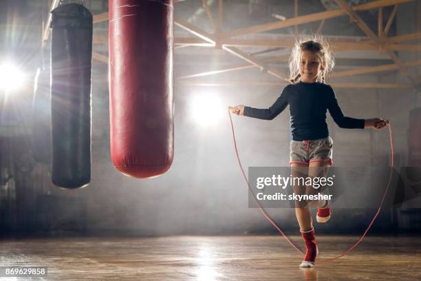 determinada a niña saltando cuerda en entrenamiento en un gimnasio deportivo. - dar brincos fotografías e imágenes de stock