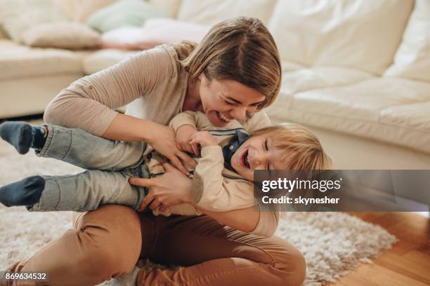 joyful mother and her small son having fun at home. - tickling stock pictures, royalty-free photos & images