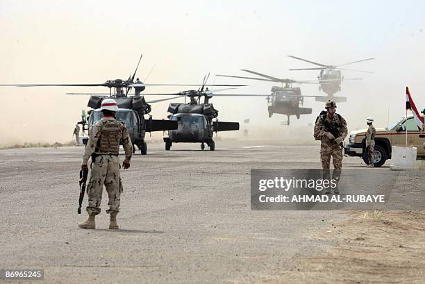 British soldier walks along as US helicopters land during training operations for Iraqi troops at a desert range some 40 kms south of the town of...