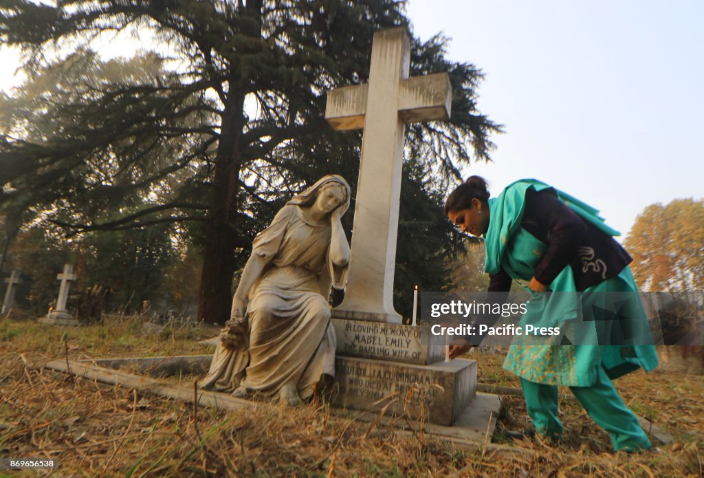 A Christian devotee lights a candle during the commemoration...