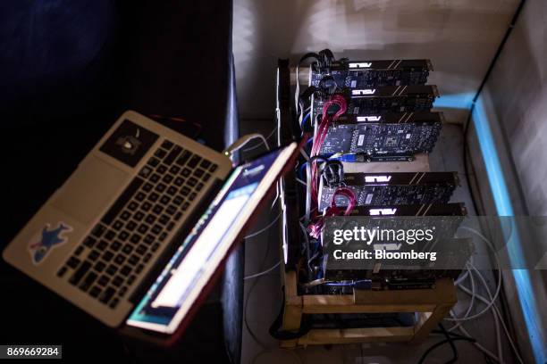 Laptop computer sits connected to a rack of Asus GeForce GTX machines, manufactured by Asustek Computer Inc., used for cryptocurrency 'mining' at the...