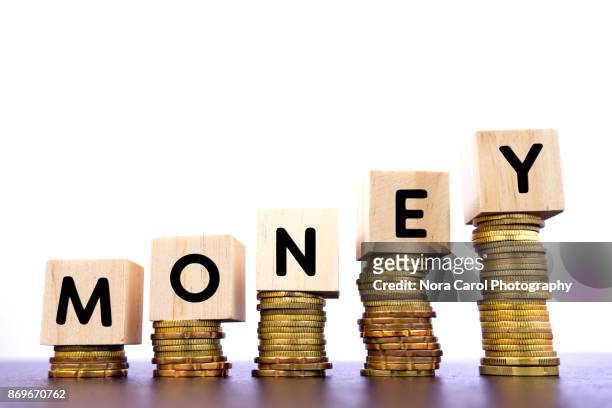 money word on wood block on top of coins stack - mutual fund stock pictures, royalty-free photos & images