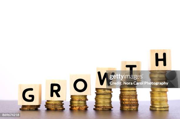 growth word on wood block on top of coins stack - carol grow stock-fotos und bilder