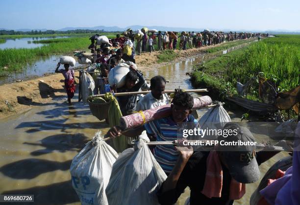 Rohingya Muslim refugees who were stranded after leaving Myanmar walk towards the Balukhali refugee camp after crossing the border in Bangladesh's...