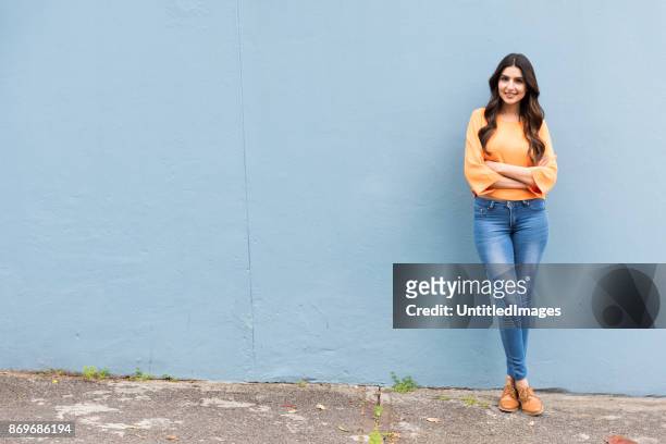 portrait of young woman standing against a wall - leaning stock pictures, royalty-free photos & images