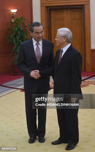 Chinese Foreign Minister Wang Yi shakes hands with Vietnam Communist Party Secretary General Nguyen Phu Trong as they meet in Hanoi on November 3,...