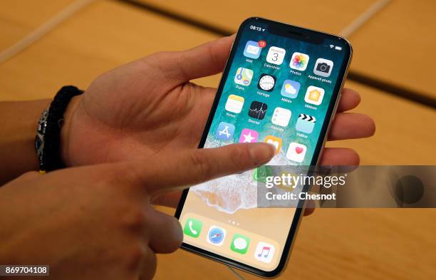 Customer holds an Apple iPhone X, the new model of Apple smartphone at the Apple Store Saint-Germain on November 3, 2017 in Paris, France. Apple's...