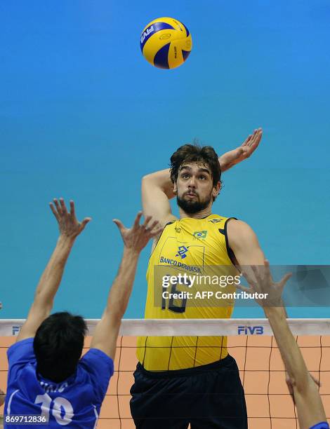 Milos Nikic of Serbia tries to stop a spike from Lucas of Brazil during their World League Group E volleyball match at Orfeo Superdomo stadium in...