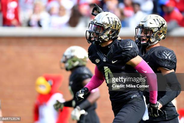 Defensive back Amari Henderson and defensive back Jessie Bates III of the Wake Forest Demon Deacons celebrate after Henderson breaks up a pass in the...