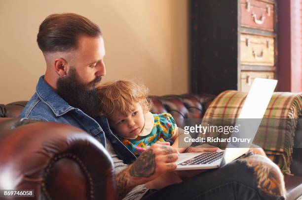 dad and toddler daughter using laptop - suffolk stock-fotos und bilder