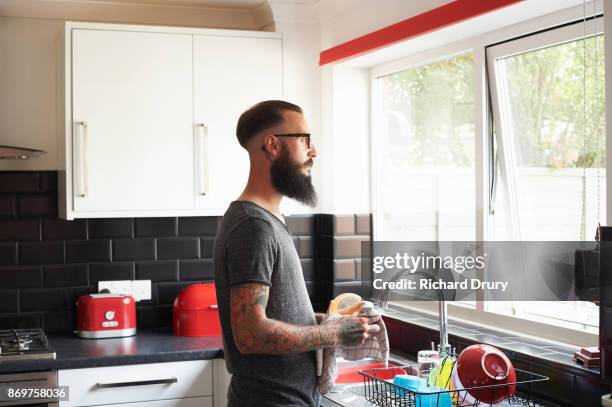 young man washing up - dish washing stock pictures, royalty-free photos & images