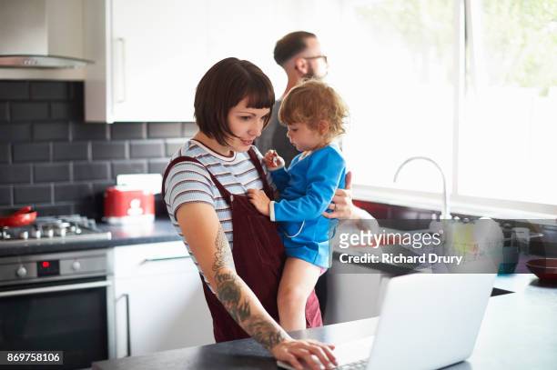 young family in their kitchen - busy woman stock-fotos und bilder