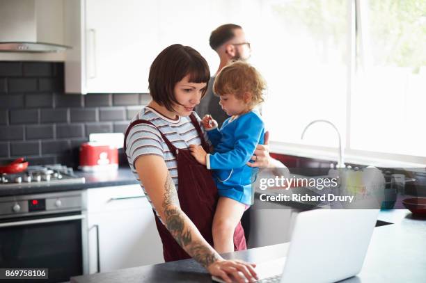 young family in their kitchen - jeune famille photos et images de collection