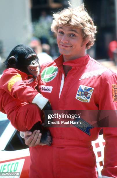 John Schneider who starred as Beauregard "Bo" Duke in The Dukes of Hazzard holds a monkey on the set.. The Dukes of Hazzard was an American...