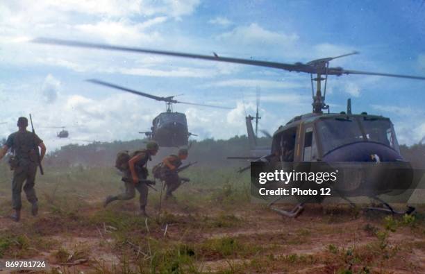 Photograph of American troops running towards a chopper during the Vietnam War. Dated 1970.