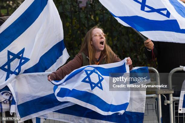 Pro-Israeli demonstrator holds a national flag in support of Israel's Prime Minister Benjamin Netanyahu, as he outlines his governments foreign...