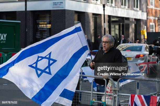 Pro-Israeli demonstrator holds a national flag in support of Israel's Prime Minister Benjamin Netanyahu, as he outlines his governments foreign...