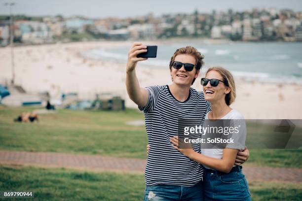 selfie on the beach - person looking at phone while smiling australia stock pictures, royalty-free photos & images