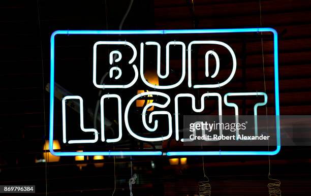 Bud Light neon sign hangs in the window of a store in New York, New York.