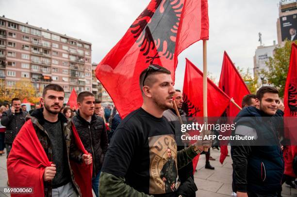 Kosovo Albanians waving Albanian national flags take part in a demonstration in Pristina, on November 3 to protest against the verdict of the...