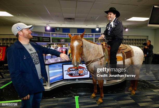 Dale Earnhardt Jr. , driver of the Nationwide/Justice League Chevrolet, speaks with Texas Motor Speedway president, Eddie Gossage, during a press...