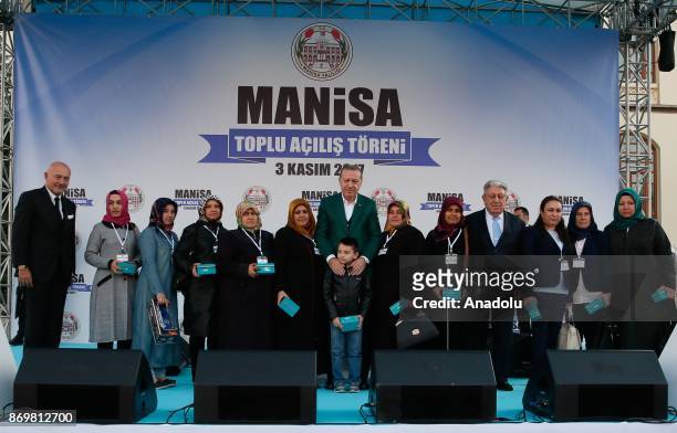Turkish President Recep Tayyip Erdogan and Chairman of Turkey's Dogus Holding Ferit Sahenk poses for a photo with relatives after they gave a key of...