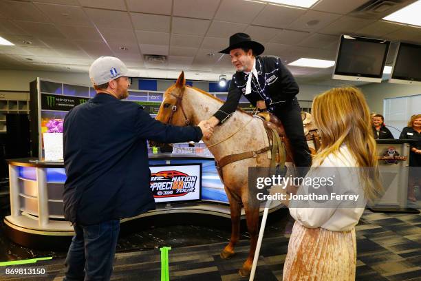 Dale Earnhardt Jr. , driver of the Nationwide/Justice League Chevrolet, and his wife, Amy Earnhardt , talk with Texas Motor Speedway president, Eddie...