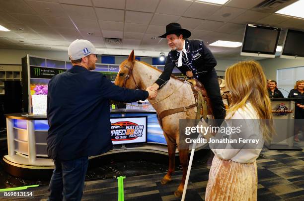 Dale Earnhardt Jr. , driver of the Nationwide/Justice League Chevrolet, and his wife, Amy Earnhardt , talk with Texas Motor Speedway president, Eddie...